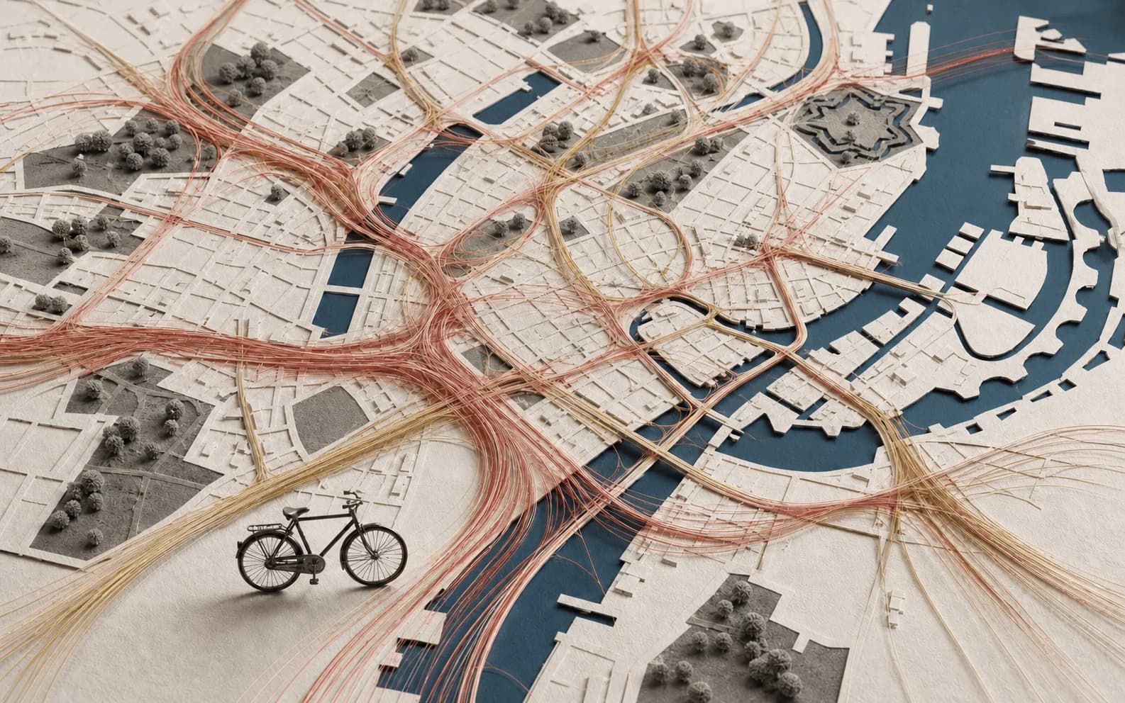 An overhead paper map of Copenhagen filled with luminous bicycle-flow trails